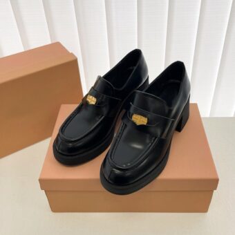 Black loafers on a brown shoebox