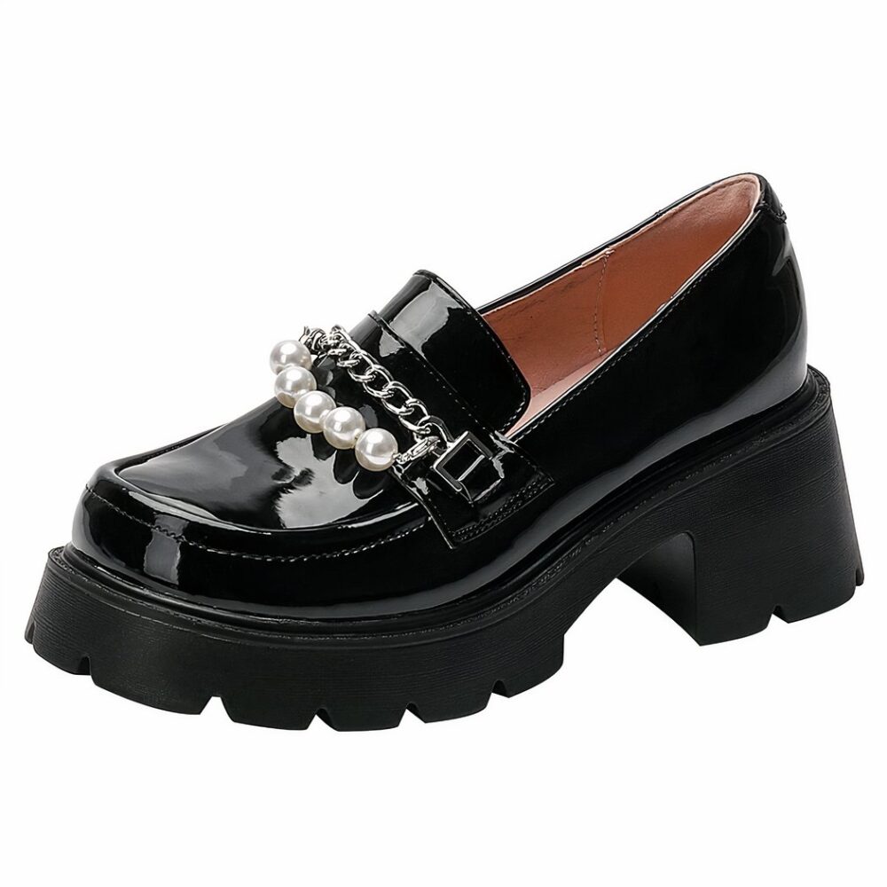 A black patent leather moccasin with thick black sole and heel decorated with a silver chain and white beads on the top of the shoe, the interior is powder pink, on a plain white background.