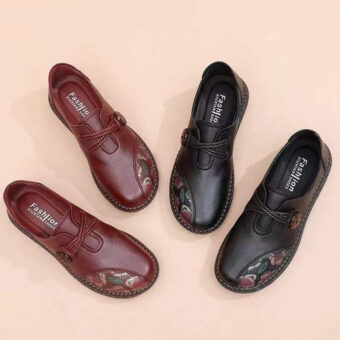 Two pairs of shoes on the floor. One red and one black with flower motifs on the front.
