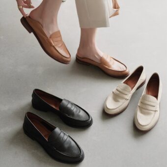 On a gray carpet, 3 pairs of beige, brown and black moccasins presented by a gentleman's feet