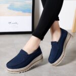 woman wearing blue suede wedge loafers