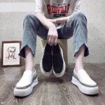 moccasin in black or white faux leather worn by a woman