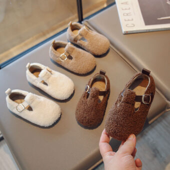 white, beige and brown faux fur moccasin on a table, a pair of brown fur moccasins held in one hand