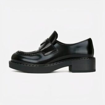 black leather moccasin with small heel set on a white background