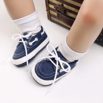 Baby legs wearing white socks and blue boat-style moccasins