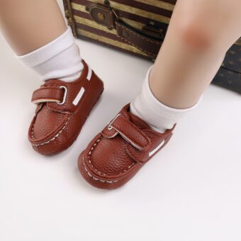 Baby wearing white socks and brown boat-style moccasins