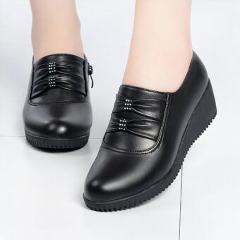 Comfortable black leather-effect wedge loafers for women with a white background