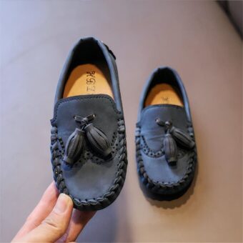 Elegant tassel loafers for boys with beige background