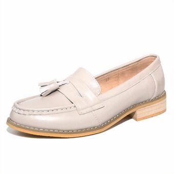 Moccasin with beige tassels in profile on a white background