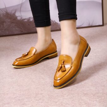 Standing woman wearing black pants and camel leather loafers