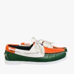 Three-tone orange, green and white boat moccasins on a grey floor in profile