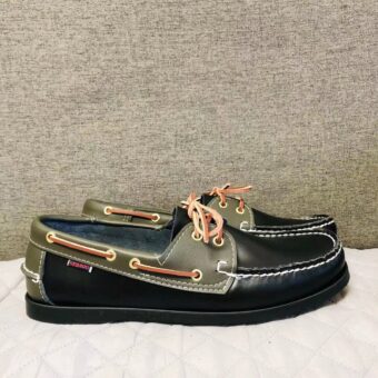 Pair of black and khaki boat moccasins on a white floor in profile
