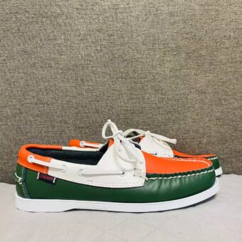 Three-tone orange, green and white boat moccasins on a grey floor in profile