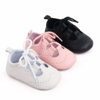 Three baby lace-up moccasins lined up diagonally in white, pink and black