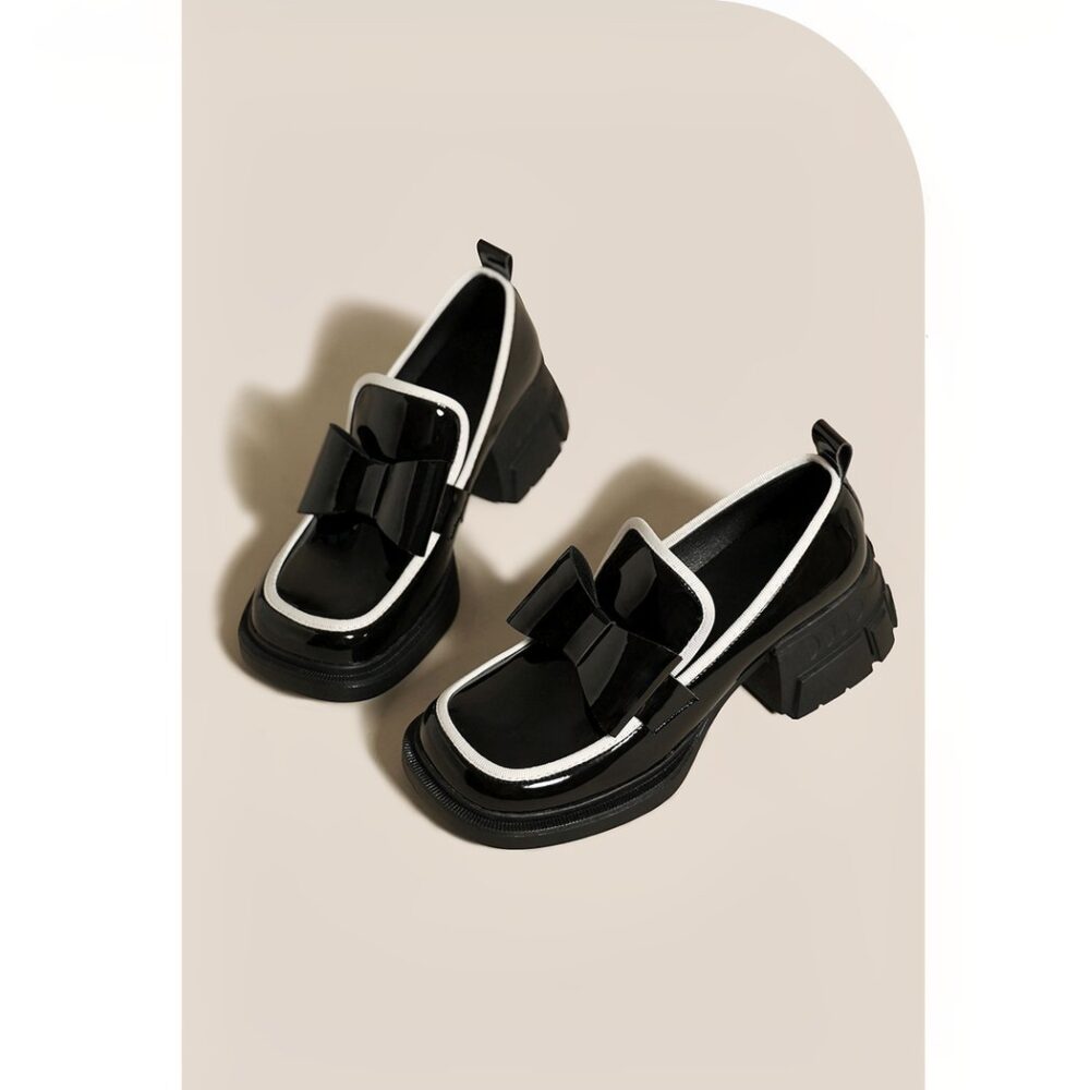 Platform loafers adorned with a ravishing black bow tie for women with a beige background