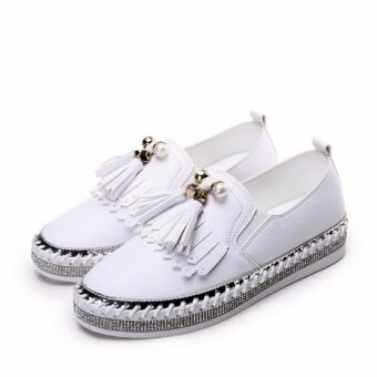 Pair of white moccasins with rhinestones and bangs on the front, on a white background