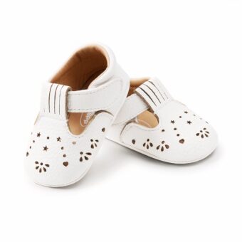 Pair of white openwork baby girl moccasins on a white background