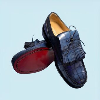 Classic crocodile-effect tassel loafers for men with a blue background