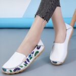 Slip-on leather moccasins in a floral pattern for women with a grey and blue background