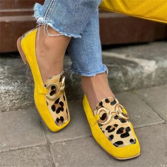 Woman standing in the street wearing jeans and yellow and leopard square-toe loafers