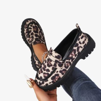 Women's loafers with a bold leopard print, perfect for a trendy look. These shoes feature thick, black notched soles, offering both style and grip. The design includes a decorative bride on top for an elegant finish.