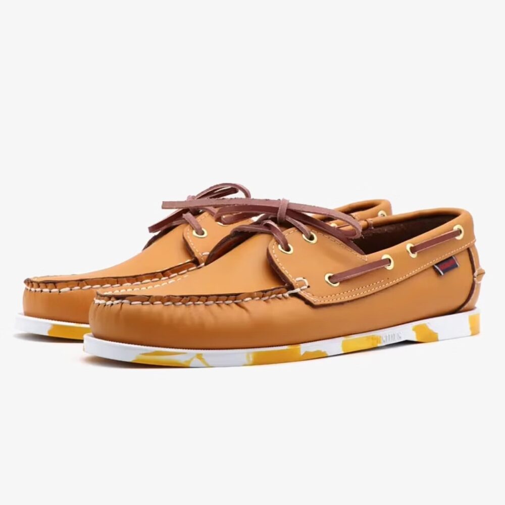 Brown leather boat loafers with colored sole for men on a white background