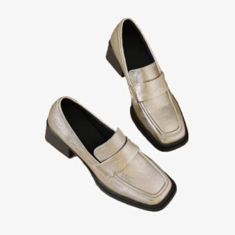 Gold heeled loafers for women on a white background