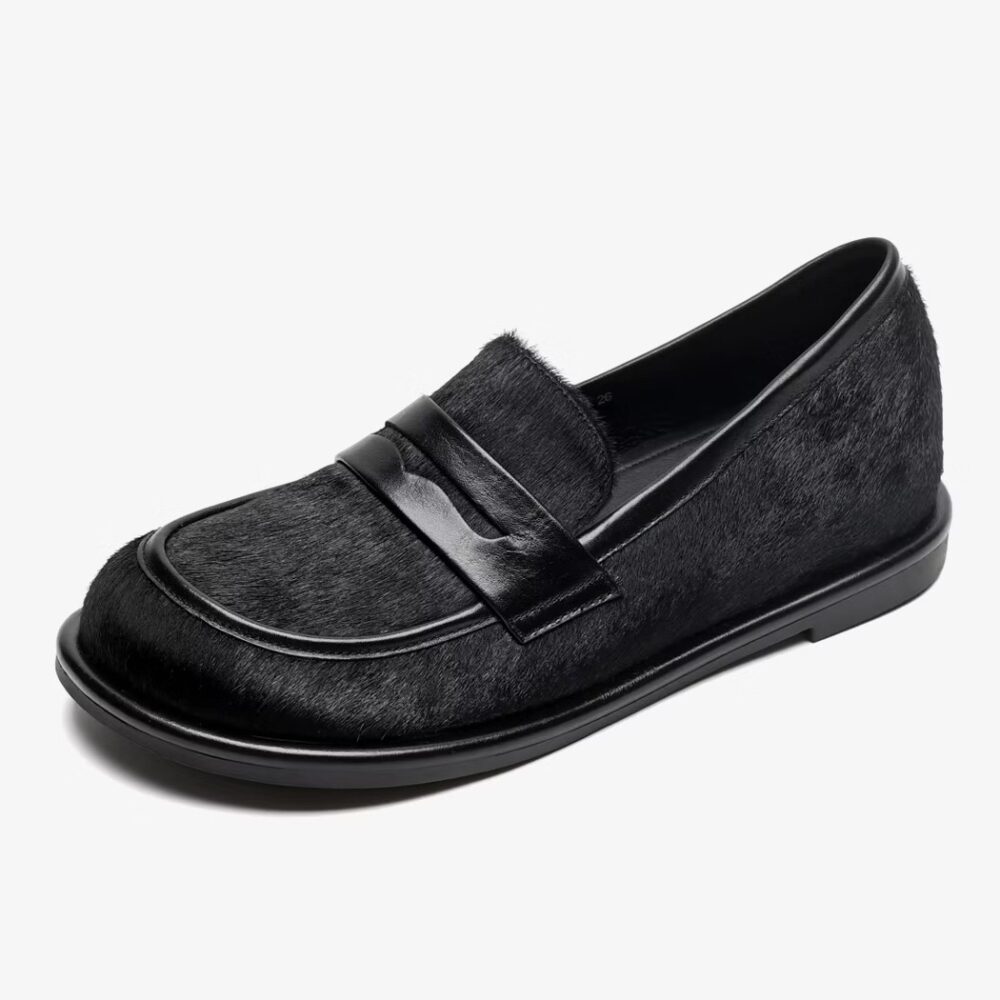 Single black leather and horsehair loafer on a white background