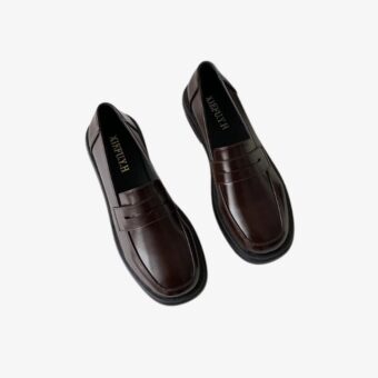 Pair of elegant classic loafers for women on a white background.