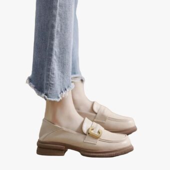 we see the feet of a woman wearing jeans and soft elegant genuine leather loafers for women