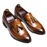 Genuine leather dress loafers with tassels for men on a white background